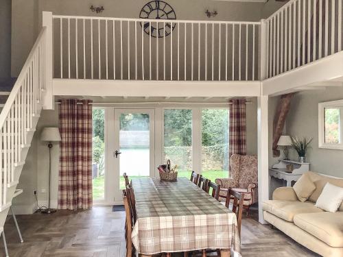 a dining room with a table and a couch at The Threshing Barn- 25347 in Findern