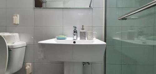 a white bathroom with a sink and a toilet at Comfy & Cozy in Seoul