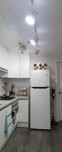 a kitchen with white cabinets and a white refrigerator at Comfy & Cozy in Seoul