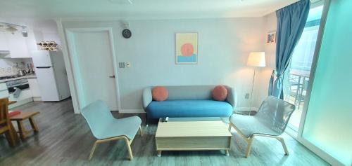 ein Wohnzimmer mit einem blauen Sofa und 2 Stühlen in der Unterkunft Comfy & Cozy in Seoul