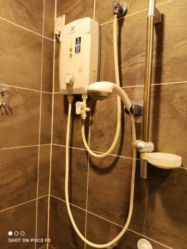 a white hair dryer on the wall of a bathroom at Cozy Studio unit,Cyberjaya,Wifi, Netflix,Free parking in Cyberjaya