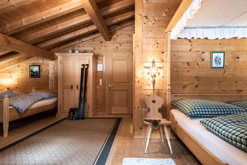 a bedroom with two beds in a wooden cabin at Gämsle Hotel, Wirtshaus & mehr in Schoppernau