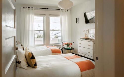 a bedroom with two beds and a window at The Bentley Inn in Bay Head