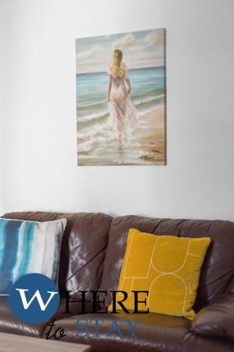 a painting of a woman walking on the beach at Entire Modern House City Center in Barrow in Furness