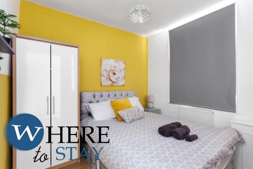 a bedroom with a bed with a yellow wall at Entire Modern House City Center in Barrow in Furness