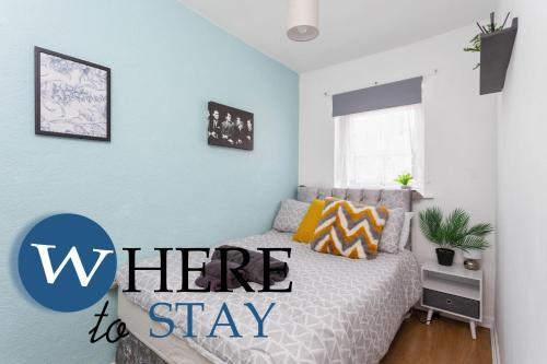 a bedroom with a bed with the words here to stay at Entire Modern House City Center in Barrow in Furness