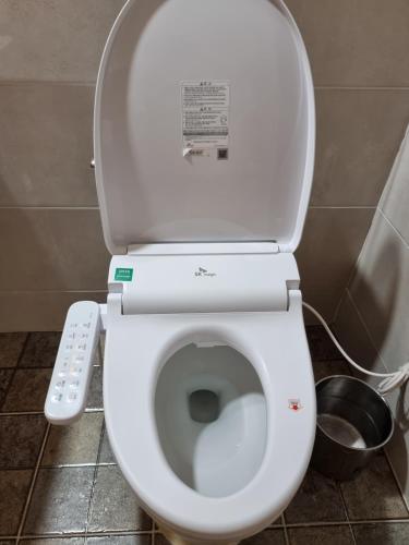 a toilet with the lid up in a bathroom at Fox Motel in Daegu