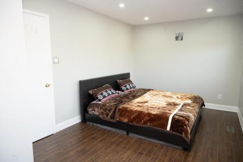 um quarto com uma cama num quarto branco em Nathan’s Place em Brampton
