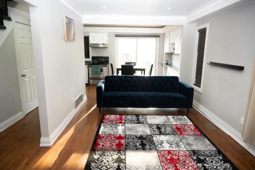 a living room with a black couch and a rug at Nathan’s Place in Brampton