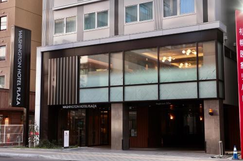 ein großes Gebäude mit Glasfenstern auf einer Stadtstraße in der Unterkunft Sapporo Washington Hotel Plaza in Sapporo