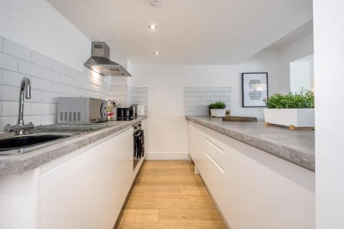 a kitchen with white counters and a sink at Host & Stay - The Cavern Quarter Apartment in Liverpool