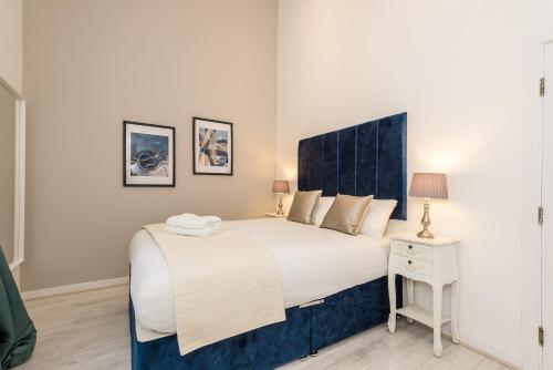 a bedroom with a large bed with a blue headboard at Host & Stay - City Centre Duplex Apartment in Liverpool