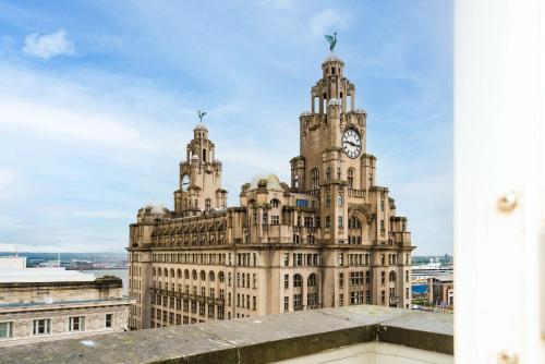 a building with a clock tower on top of it at Host & Stay - Waterfront Penthouse in Liverpool