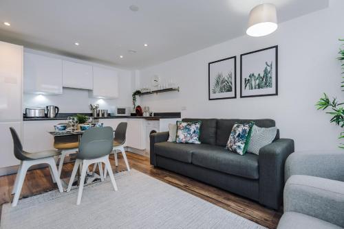 ein Wohnzimmer mit einem Sofa und einem Tisch sowie eine Küche in der Unterkunft Host & Stay - Waterfront Penthouse in Liverpool