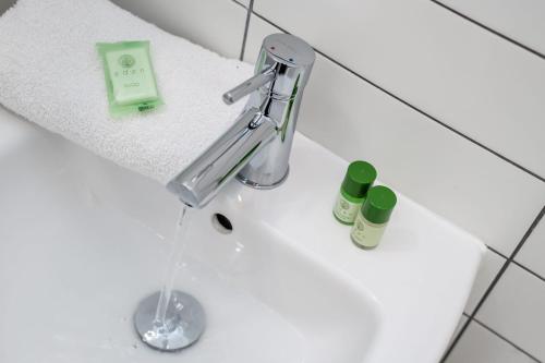 a sink with a faucet and two bottles on it at Host & Stay - The Roscoe Carriage House in Liverpool