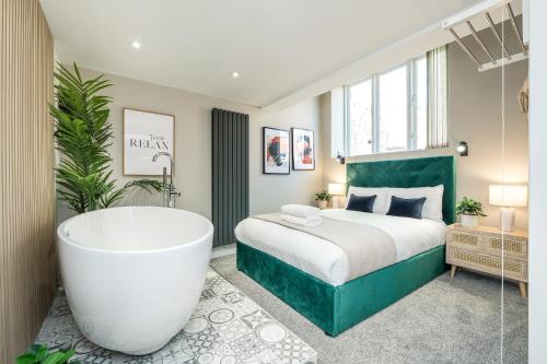 a bedroom with a large bed and a bath tub at Host & Stay - The Georgian Coach House 1 in Liverpool