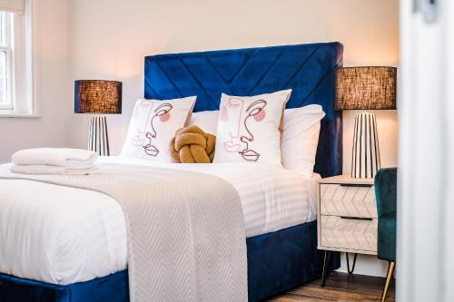a bed with a blue headboard with a teddy bear on it at Host & Stay - The Rodney Townhouse in Liverpool