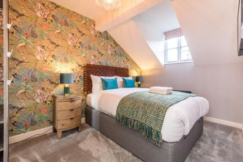 a bedroom with a large bed with a floral wallpaper at Host & Stay - The Pilgrim Coach Houses in Liverpool