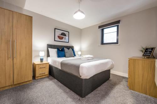 a bedroom with a large bed with blue pillows at Host & Stay - Ropewalks Apartment in Liverpool