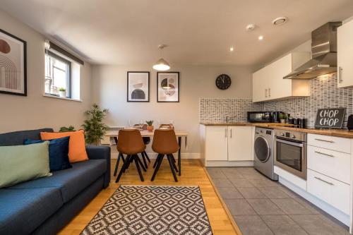 a living room with a blue couch and a kitchen at Host & Stay - Ropewalks Apartment in Liverpool