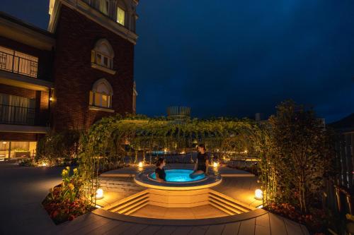 a courtyard with a fountain in front of a building at ROYAL CHESTER NAGASAKI hotel&retreat in Nagasaki