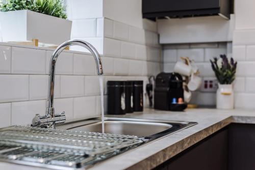 a kitchen sink with a dish rack next to it at Host & Stay - The Roscoe Coach House in Liverpool