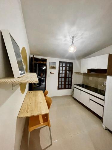 a kitchen with white cabinets and a wooden table at Residencial Temporada Aracaju in Aracaju