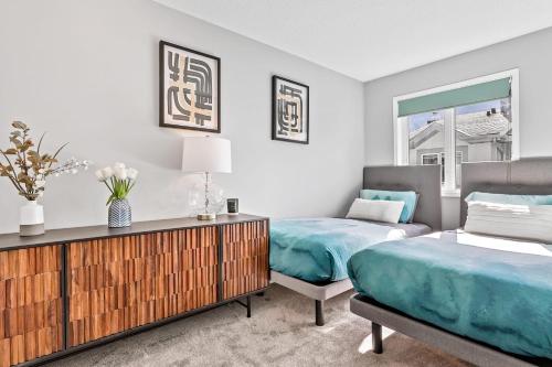 a bedroom with two beds and a dresser at The Alfar by Samsara Resort Private Entry Panorama Top View 3BR 2TH in Canmore