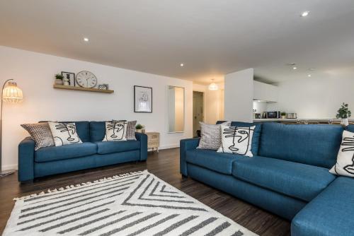 a living room with two blue couches and a rug at Host & Stay - The Scandi Hideaway in Liverpool