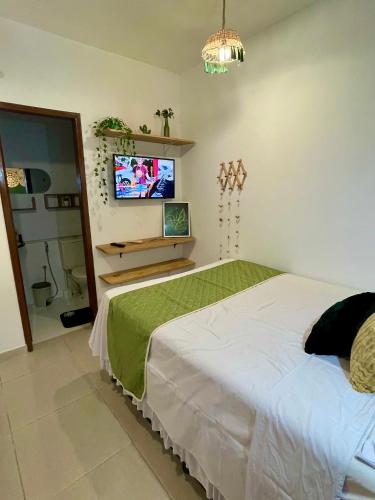 a bedroom with a bed and a flat screen tv at Residencial Temporada Aracaju in Aracaju
