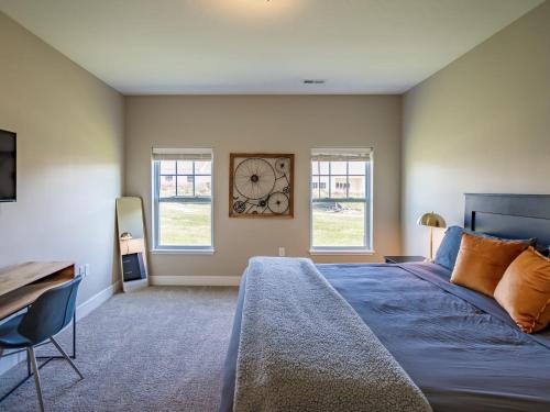 1 dormitorio con 1 cama y reloj en la pared en Modern 2BR 2BA New Build Condo with Garage & Patio, en Wyoming