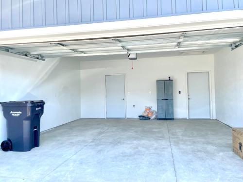 an empty garage with three doors and a trash can at Modern 2BR 2BA New Build Condo with Garage & Patio in Wyoming