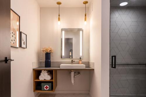 La salle de bains est pourvue d'un lavabo et d'un miroir. dans l'établissement The Finnley Hotel, à Grand Rapids
