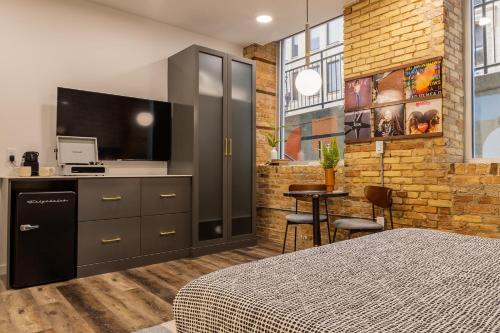 a bedroom with a bed and a flat screen tv at The Finnley Hotel in Grand Rapids