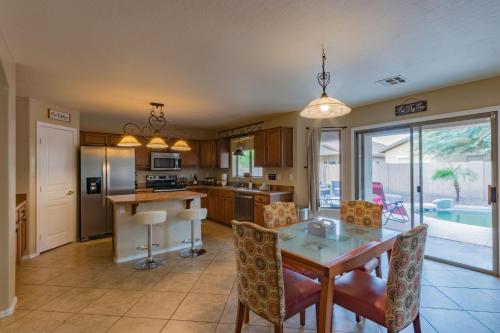 a kitchen and dining room with a table and chairs at Desert Oasis Amazing Pool Waterfall Firepit Office in Casa Grande
