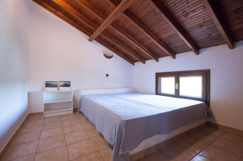 a bedroom with a large bed and a window at Wonderful villa with huge yard, at Potamos beach in Epanomi