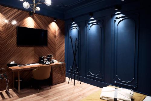 a room with a desk and a tv on a wall at HOTEL VIENA in Satu Mare