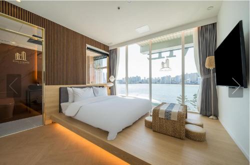 a bedroom with a bed and a large window at De Homme Hotel in Busan