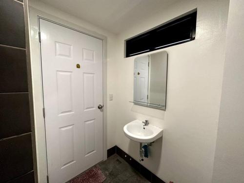 a bathroom with a white door and a sink at Minimalist studio unit in Davao City
