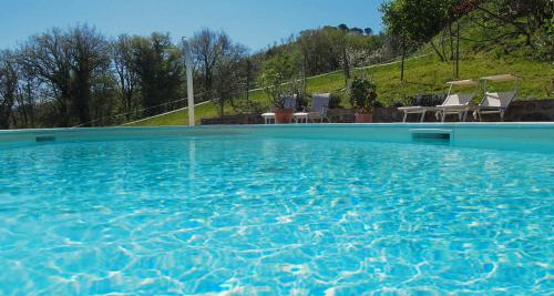 a large blue swimming pool with two chairs in it at SommaVilla B&B in Vicchio