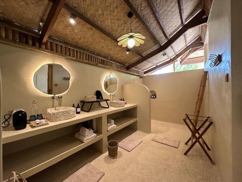 a bathroom with two sinks and a mirror at The Beach House Ocam Ocam in Busuanga
