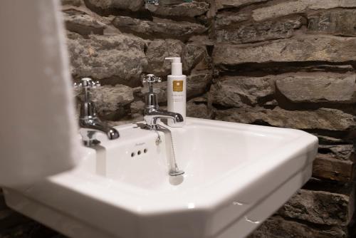 a bathroom sink with a bottle of soap on it at Romantic rural couples retreat in the stunning village of Crosthwaite, Lyth Valley in Kendal