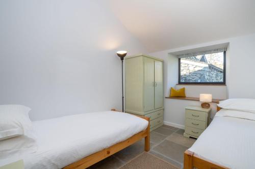 1 Schlafzimmer mit 2 Betten und einem Fenster in der Unterkunft Grasmere Cottage with Stunnng Views by LetMeStay in Ambleside