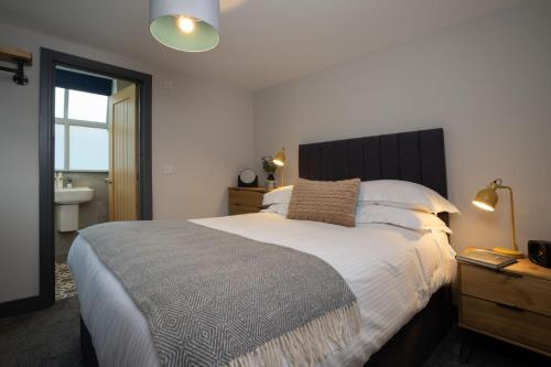 a bedroom with a large bed and a bathroom at Spacious - Contemporary 2BR Apartment - Central Ambleside - Parking in Ambleside