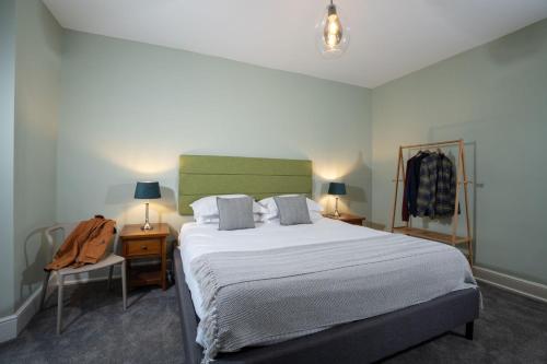 ein Schlafzimmer mit einem großen Bett, zwei Lampen und einem Stuhl in der Unterkunft Spacious Home with Outstanding Views by LetMeStay in Ambleside
