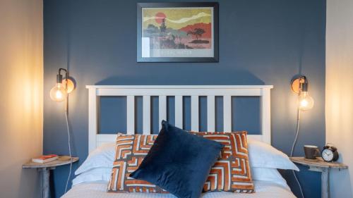 Schlafzimmer mit blauen Wänden und einem Bett mit Kissen in der Unterkunft Calm - 1BR - 1BA - Apartment - Central Ambleside in Ambleside