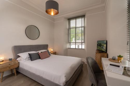 um quarto com uma cama branca e uma secretária. em Spacious Apartment in Coniston, by LetMeStay em Coniston
