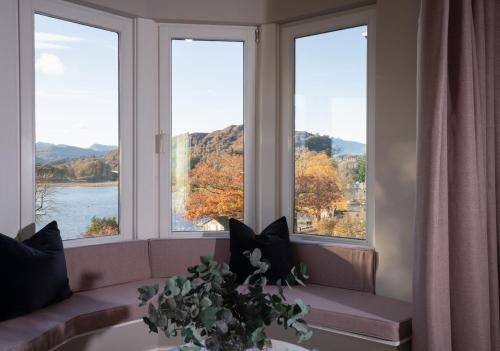 a room with three windows with a view of a lake at Brand New - Contemporary - 2 Bedroom - 2 Bathroom - Spacious Apartment - Lake Views in Ambleside