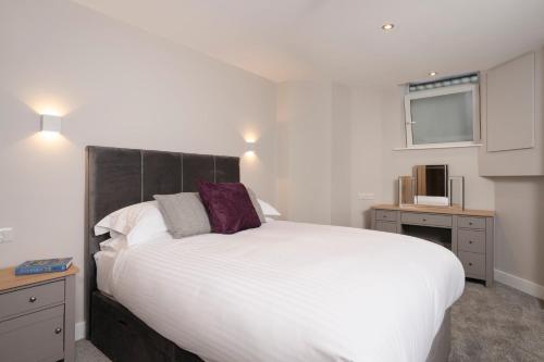 a bedroom with a large white bed and a window at The Hideaway with Cosy Fireplace by LetMeStay in Ambleside