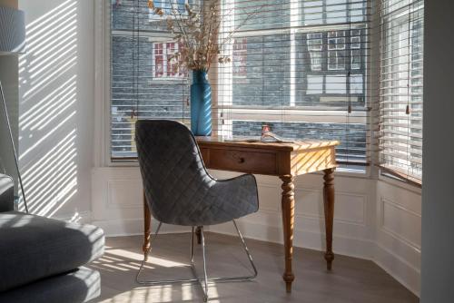 a desk and a chair in a room with windows at Redbanks Apartment in Ambleside
